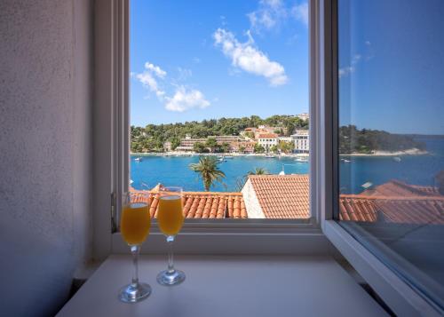 two wine glasses sitting on a window sill with a view at The Renaissance in Hvar