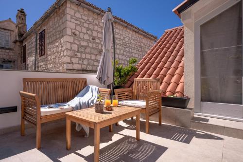 eine Terrasse mit einem Tisch und einem Sonnenschirm in der Unterkunft The Renaissance in Hvar