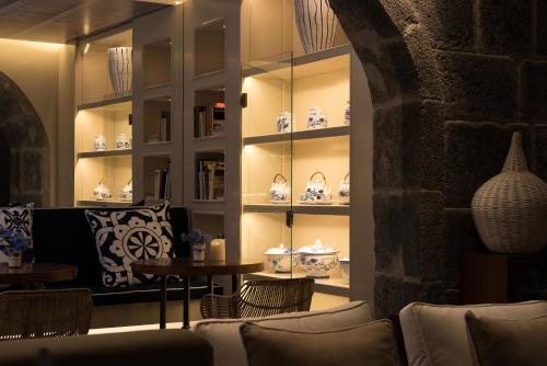 a room with couches and tables and vases on shelves at Hotel Casa Hintze Ribeiro in Ponta Delgada