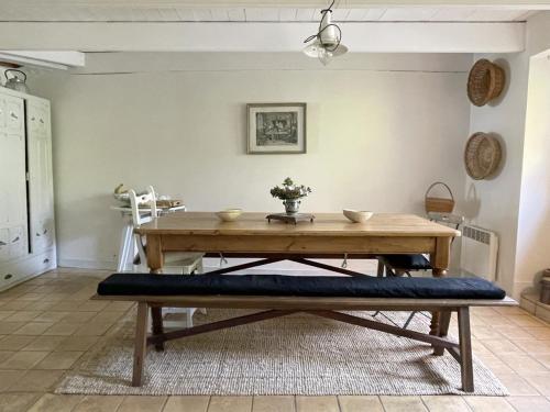 une salle à manger avec une table en bois et un banc dans l'établissement Maison de charme avec jardin clos, à 50m des commerces et proche plage, pour 8 personnes - FR-1-639-54, à Arzon