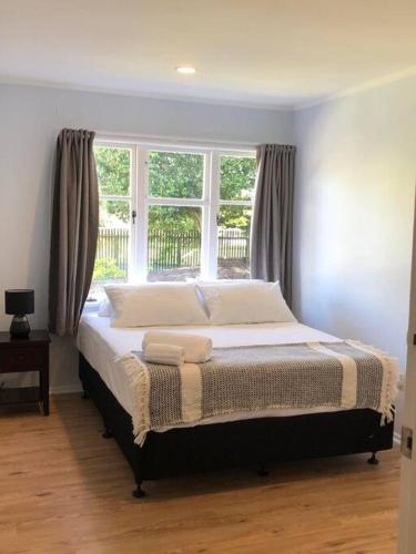 a large bed in a bedroom with a window at Family-Friendly 5-Bedroom Home Near Uni & Hamilton Gardens - Sleeps 10 in Hamilton