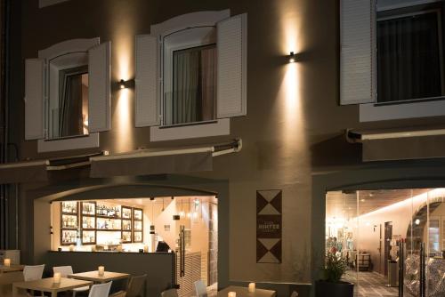 a restaurant with tables and chairs and lights on the wall at Hotel Casa Hintze Ribeiro in Ponta Delgada