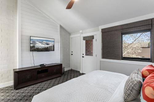 a bedroom with a bed and a tv on a wall at Stylish and Modern Park Ave Condo, Swimming Pool, 5 minutes to Main in Park City