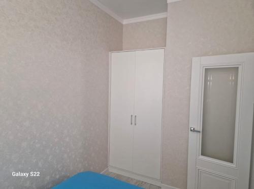 a room with a white cabinet and a door at Квартира Достар in Karagandy