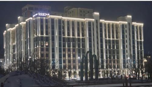 a large building with lights on it at night at Квартира Достар in Karagandy
