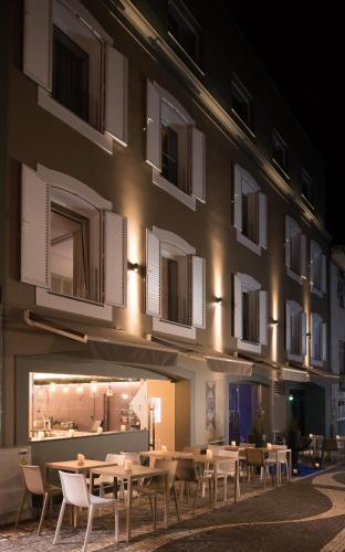 a building with tables and chairs in front of it at Hotel Casa Hintze Ribeiro in Ponta Delgada