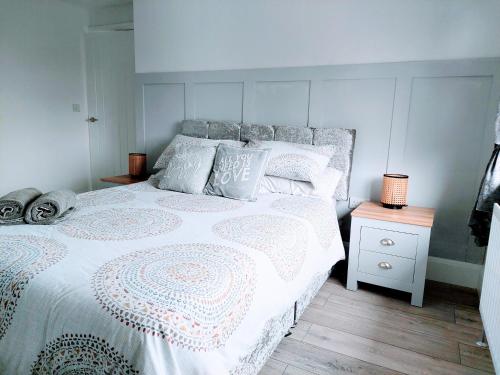 a bedroom with a white bed and a night stand at 'Serenity in Somerset ' Self Catering House Rental Near Chard , Accomodation for Contract Workers only in Chardstock