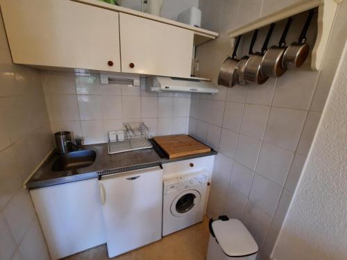 małą kuchnię z pralką i pralką w obiekcie Appartement Lumineux à Seignosse, Proche Plage, Commerces et Activités, Parking, Wifi et Balcon - FR-1-239-813 w mieście Seignosse