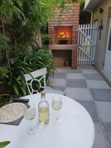 a table with two wine glasses and a fireplace at At Leisure in Worcester