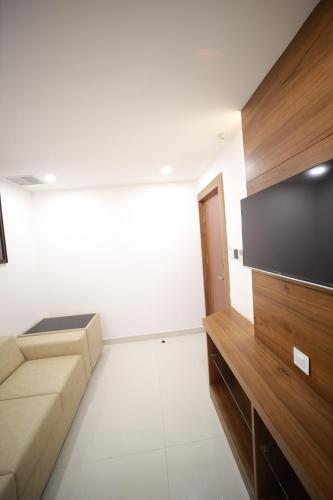 a living room with a couch and a flat screen tv at ROYAL RESIDENCY in Kānnangād