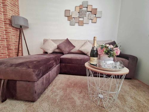 a living room with a couch and a table with a bottle of champagne at CENTAR in Brčko