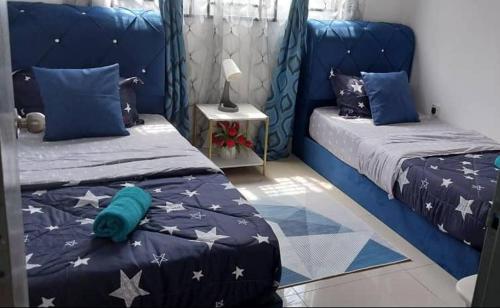 1 dormitorio con 2 camas y cabecero azul en Orkid Kluang Homestay, en Keluang
