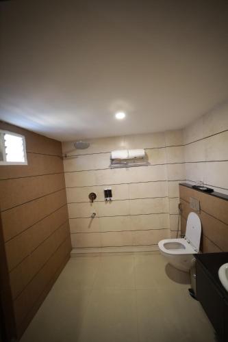 ein Bad mit einem WC und einem Waschbecken in der Unterkunft ROYAL RESIDENCY in Kānnangād