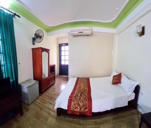 1 dormitorio con 1 cama y TV. en Khách sạn Viễn Đông en Dong Quan