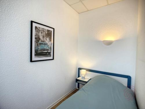 sypialnia z łóżkiem i zdjęciem na ścianie w obiekcie Studio cosy proche des Thermes, centre-ville et nature, WiFi, animaux acceptés - FR-1-451-181 w mieście Lamalou-les-Bains