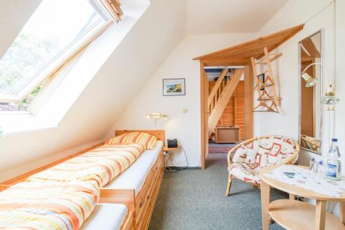 a attic room with a bench and a table at Pension Lindenkrug in Thomsdorf