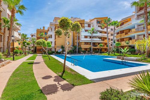 an apartment with a swimming pool in a building at Olivia Sunny 2 bedroom Apartament Punta Prima in Torrevieja