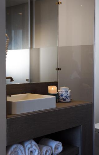 a bathroom with a sink and towels on a counter at Hotel Casa Hintze Ribeiro in Ponta Delgada