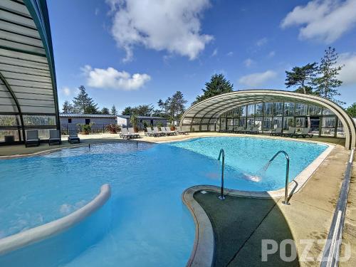 une grande piscine devant un immeuble dans l'établissement Chalet 4 pers avec piscine chauffée, terrasse privative, à 2 pas de la plage et commerces - FR-1-361-467, à Jullouville