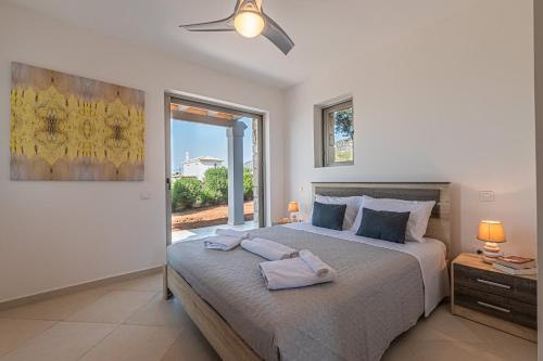 a bedroom with a large bed with towels on it at Costa Bianca Villas in Koilás