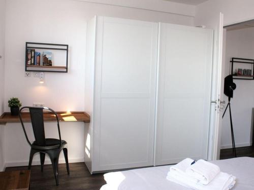 a bedroom with a large white closet and a chair at Old town view in the Ohlerich warehouse in Wismar