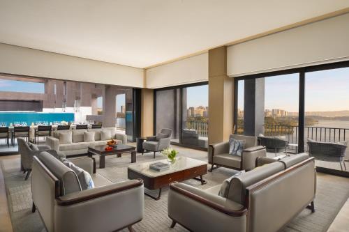 a living room with couches and tables and windows at Hyatt Regency Dongguan in Dongguan