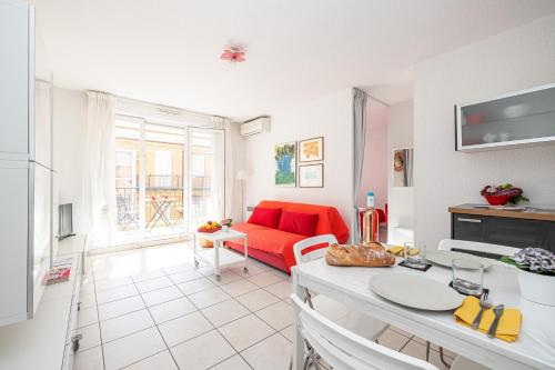 un salon avec un canapé rouge et une table dans l'établissement Royal Sunny Apt 200m From Beach - Happy Rentals, à Menton