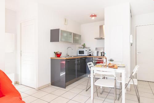 une cuisine avec une table et des chaises dans une pièce dans l'établissement Royal Sunny Apt 200m From Beach - Happy Rentals, à Menton