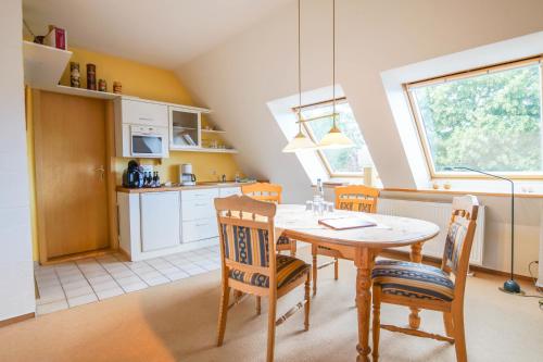 a kitchen and dining room with a table and chairs at Pension Lindenkrug in Thomsdorf