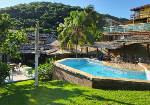 a resort with a swimming pool and a building at Pousada New Paradise in Búzios
