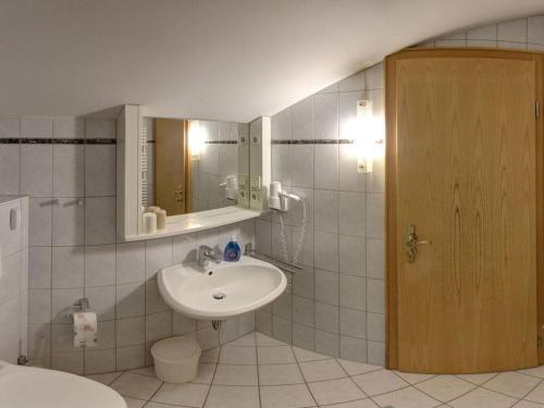 uma casa de banho com um lavatório e um espelho em Kienberg Comfortable holiday residence em Inzell