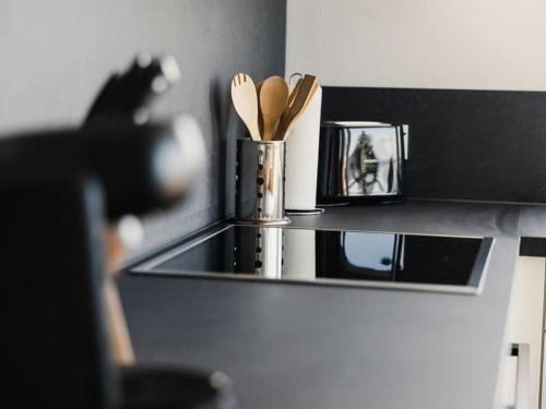 a kitchen counter with a container of wooden utensils at Holiday apartment 3 in the holiday home Sandra in Hörbranz