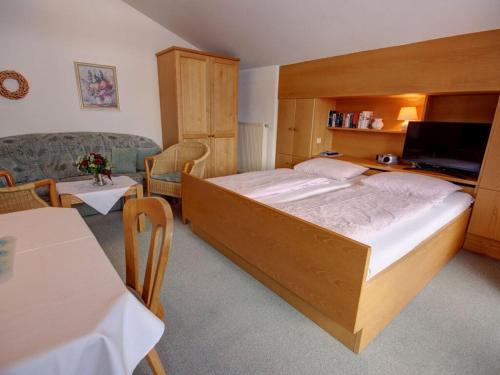 a bedroom with a large bed and a living room at Kienberg Comfortable holiday residence in Inzell