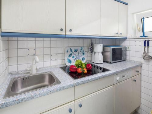encimera de cocina con fregadero y microondas en Apartment No 3 Modern retreat en Norderney