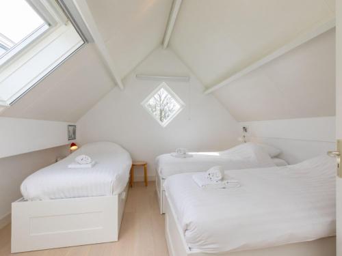 2 camas en un dormitorio ático con ventana en Enjoy Villa Querina, en Koudekerke