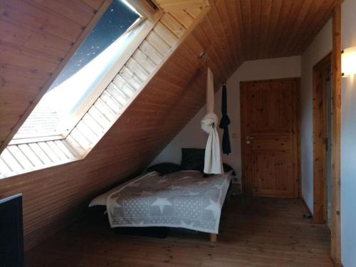a bedroom with a bed in a attic with a window at Krusch Modern retreat 