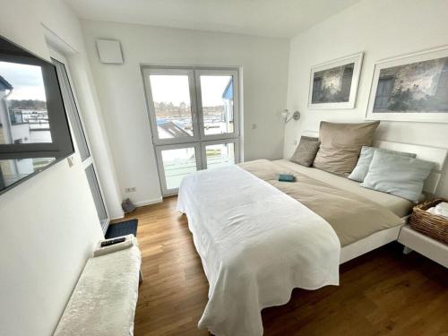 1 dormitorio con 1 cama blanca grande y ventana en "Penthouse apartment on the water" en Rechlin