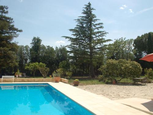 - une piscine dans une cour avec un arbre dans l'établissement Camargue Modern retreat, à Cavaillon