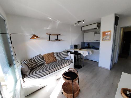 a living room with a couch and a kitchen at Appartement Seignosse, 1 pièce, 2 personnes - FR-1-239-871 in Seignosse