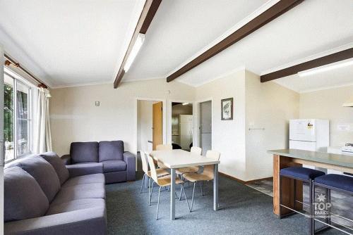 a living room with a couch and a table at Buckenderra Holiday Village in Rocky Plain