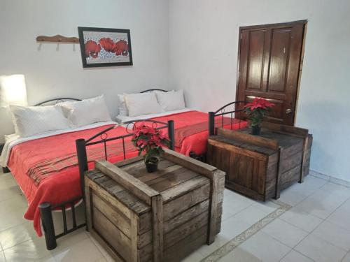 a bedroom with a bed with red sheets and wooden crates at VILLA ESCONDIDA in San Juan del Río