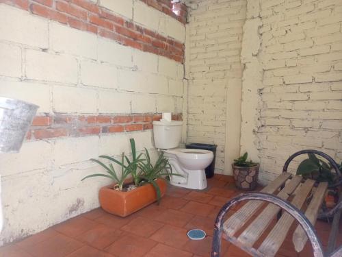 a bathroom with a toilet in a brick wall at VILLA ESCONDIDA in San Juan del Río