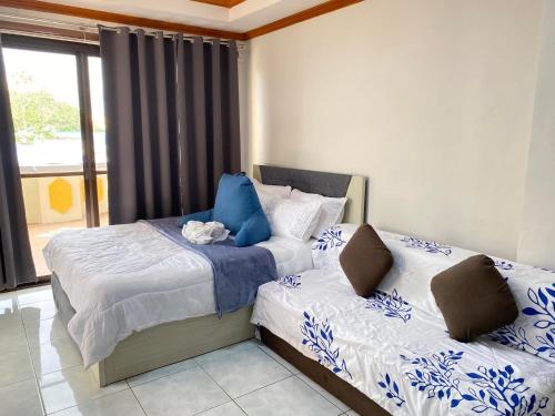 a bedroom with two beds and a window at Exclusive Beachfront House at San Juan La Union in San Juan