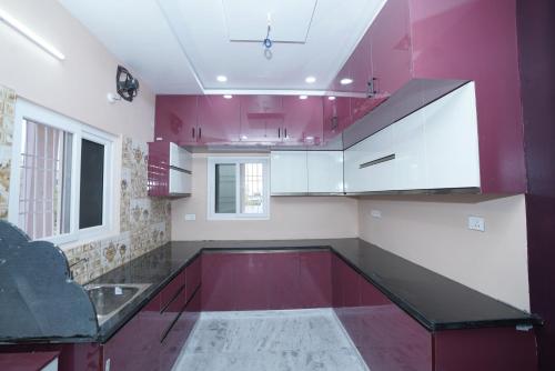 a kitchen with red and white cabinets and a sink at Katyayani Serenity - Your Premium Homestay in Bhadrāchalam