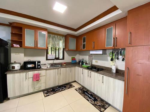 a kitchen with wooden cabinets and a counter top at Exclusive Beachfront House at San Juan La Union in San Juan