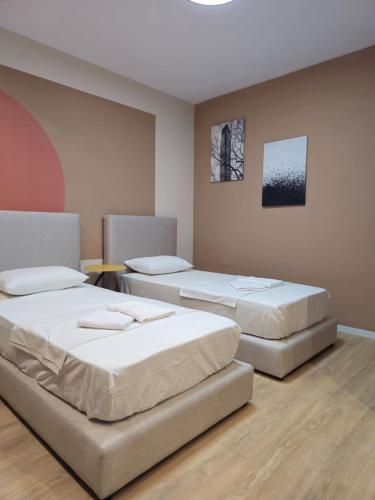 um quarto com duas camas e uma mesa em Center Cozy Nest em Tirana