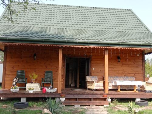 a log cabin with chairs and a porch at Agroturystyka Przy Siole Budy in Białowieża