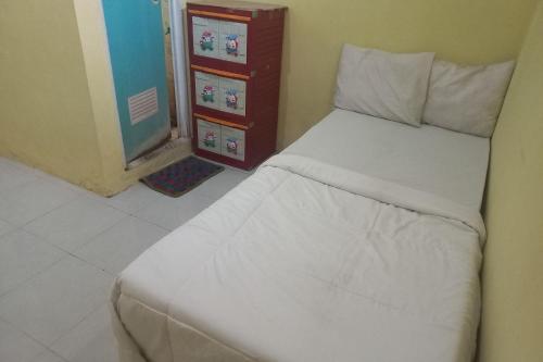 a bedroom with a white bed in a room at SPOT ON 93886 Kost Zalfa Amalia Syariah in Tegal