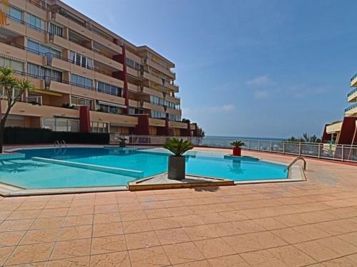 une grande piscine devant un immeuble dans l'établissement Appartement 4 pers, piscine, parking, climatisation en bord de mer - FR-1-338-508, à Sète