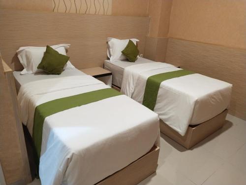 A bed or beds in a room at Hotel Kembang Joyo